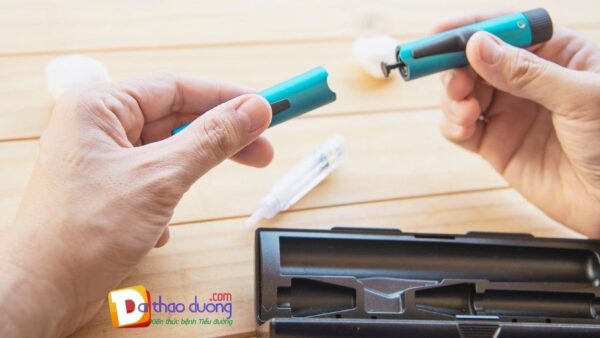 Người cầm bút tiêm insulin màu xanh.